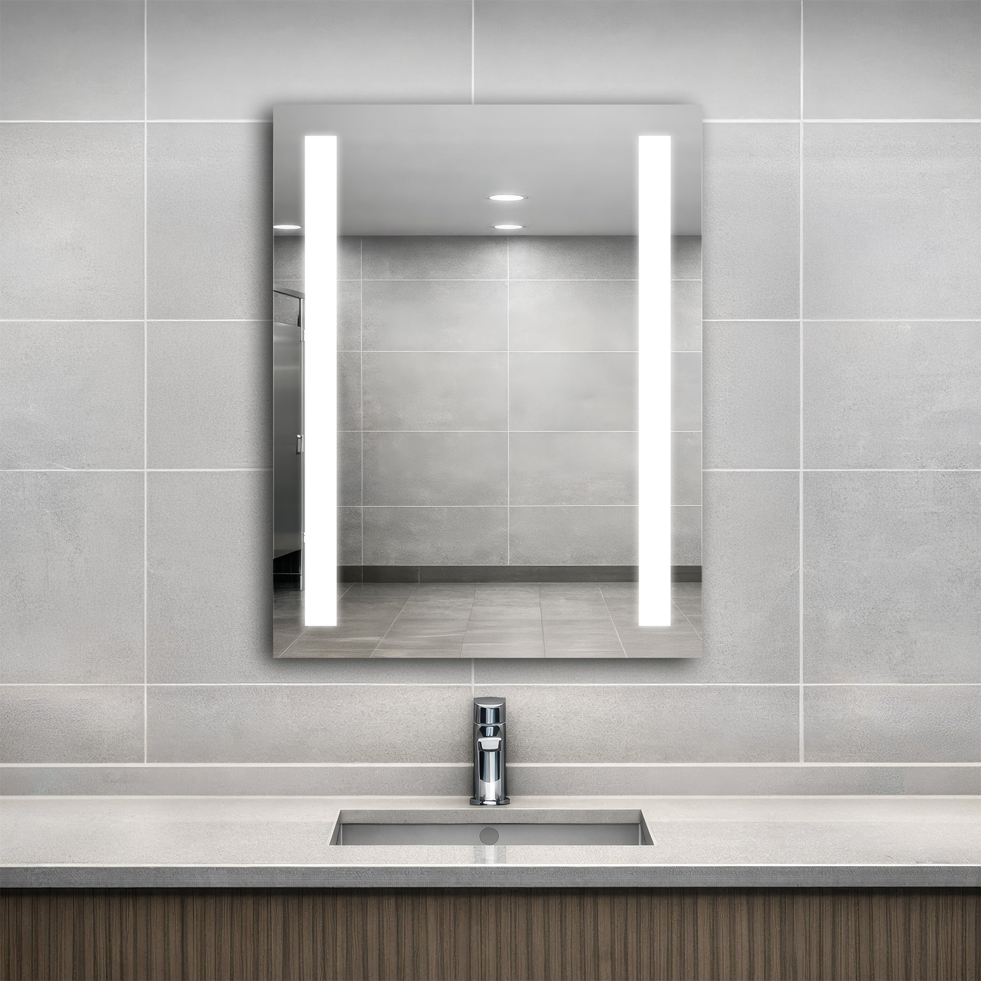 Bathroom with a modern sink and Ledge lighted mirror on a tiled wall.