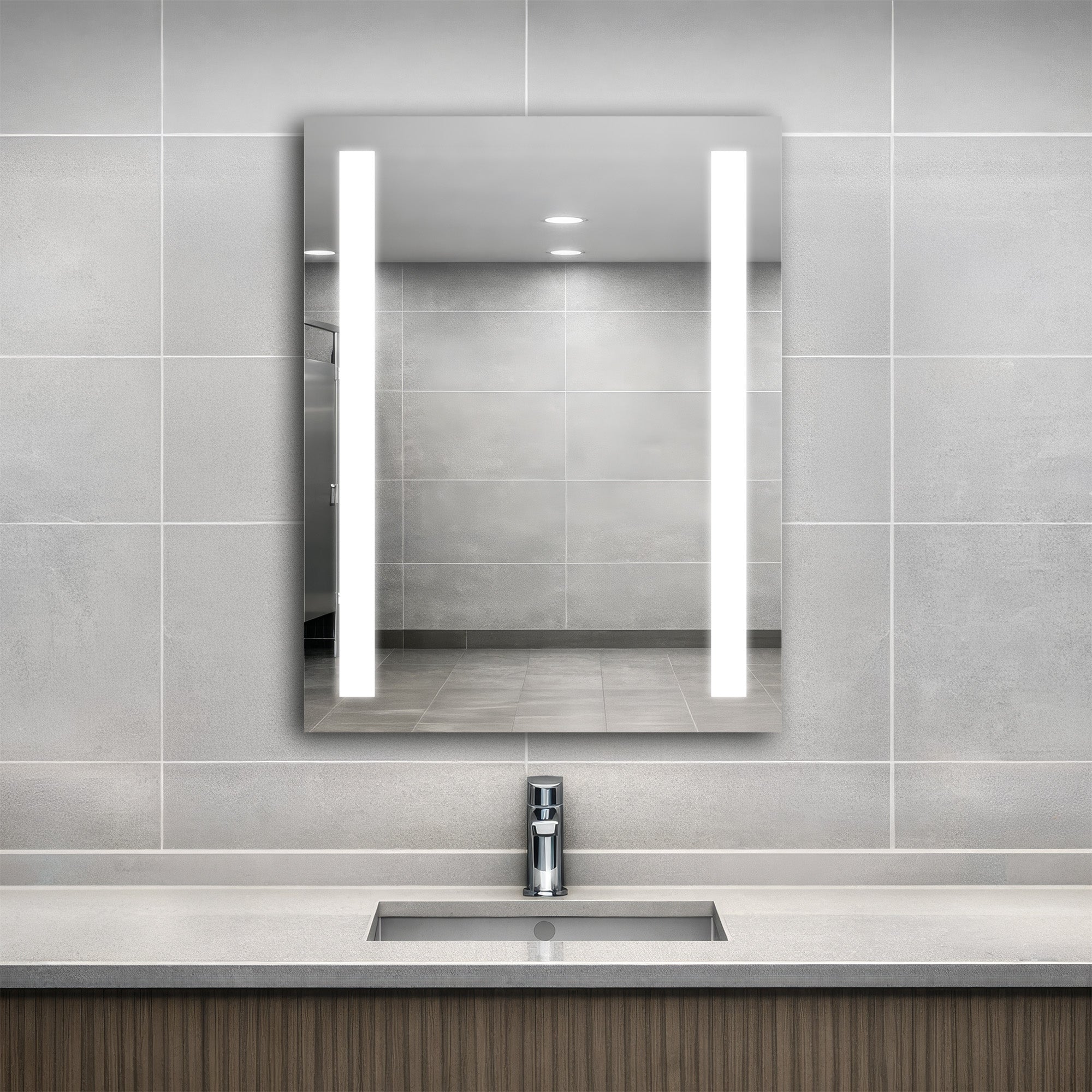 Bathroom with a modern sink and Ledge lighted mirror on a tiled wall.