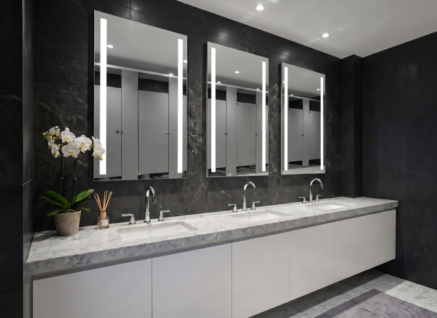 Bathroom with three Ledge lighted mirrors above a vanity.