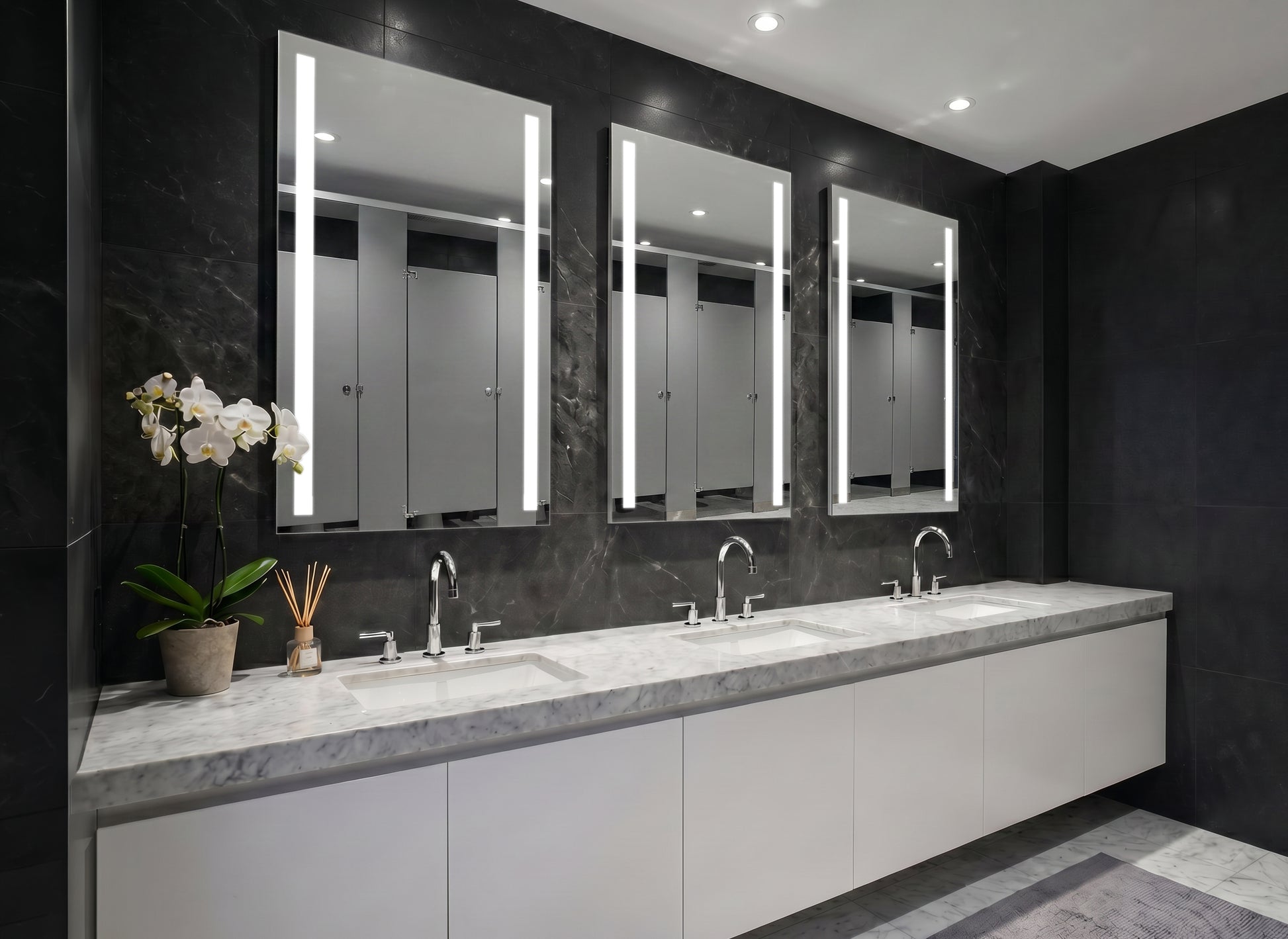 Bathroom with three Ledge lighted mirrors above a vanity.